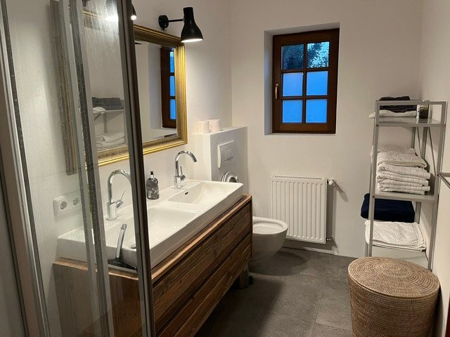 Badezimmer mit Goldrahmen-Spiegel und Holzvanity