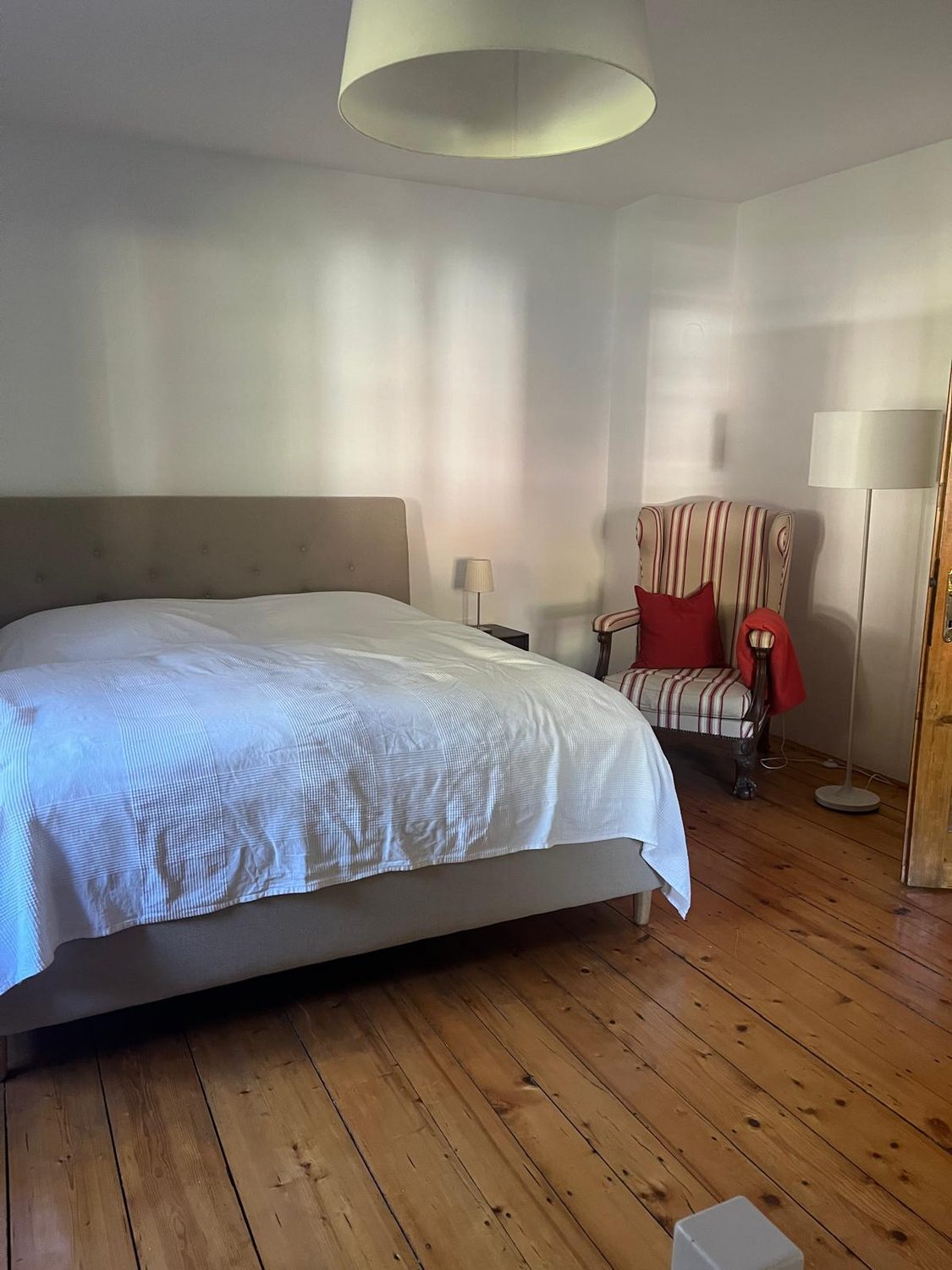 Schlafzimmer mit Doppelbett, Sessel und Stehleuchte