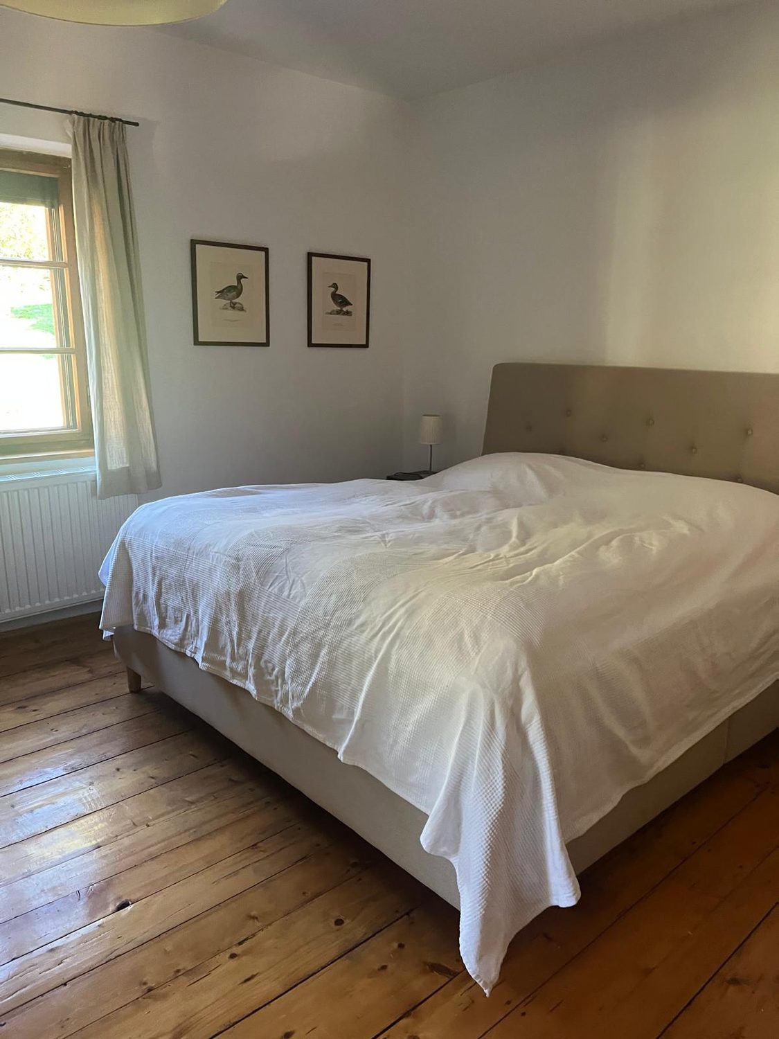 Schlafzimmer mit Doppelbett und zwei gerahmten Bildern