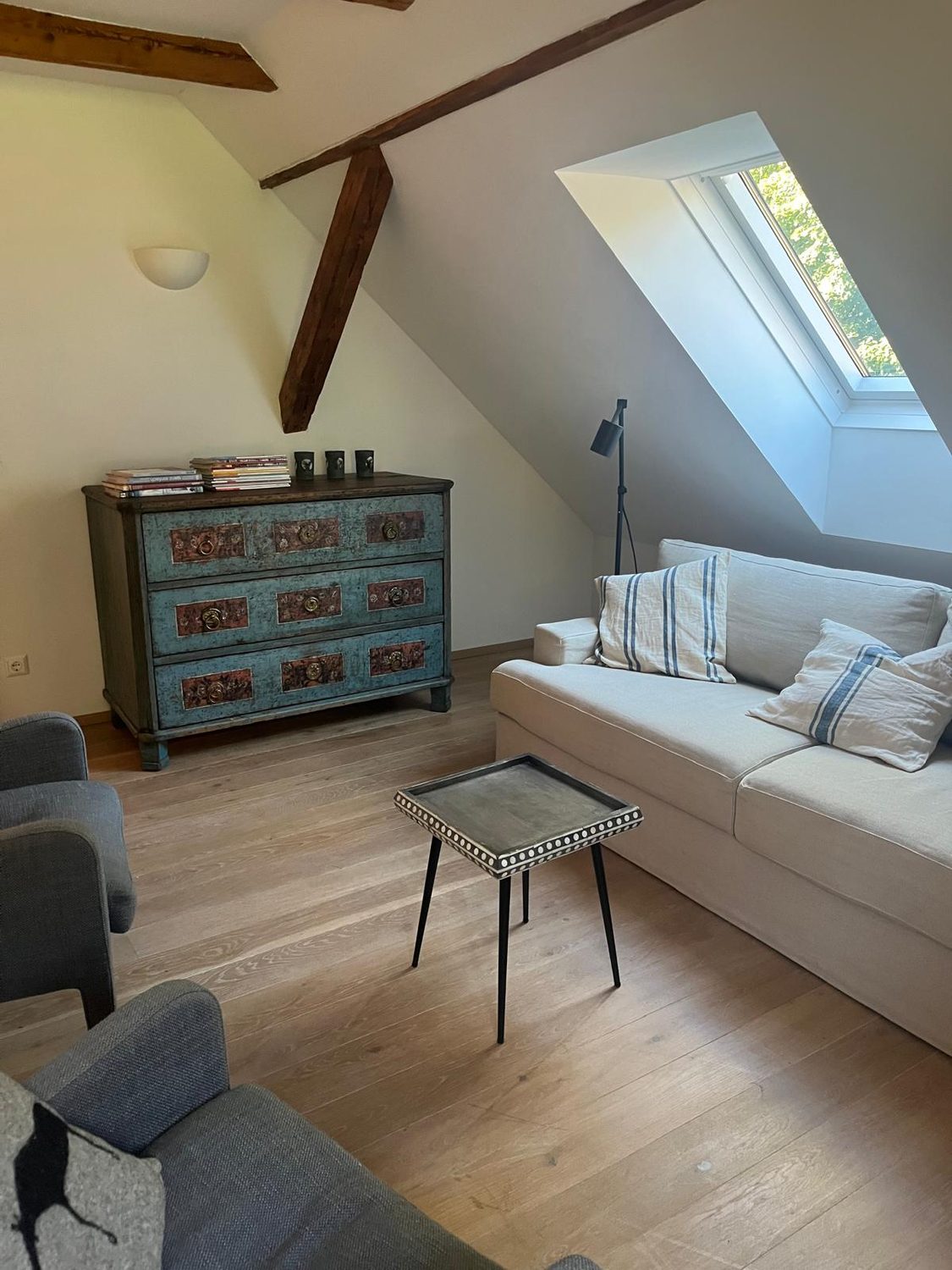 Zweiter Wohnraum unterm Dach mit blauer antiker Kommode und Sofa