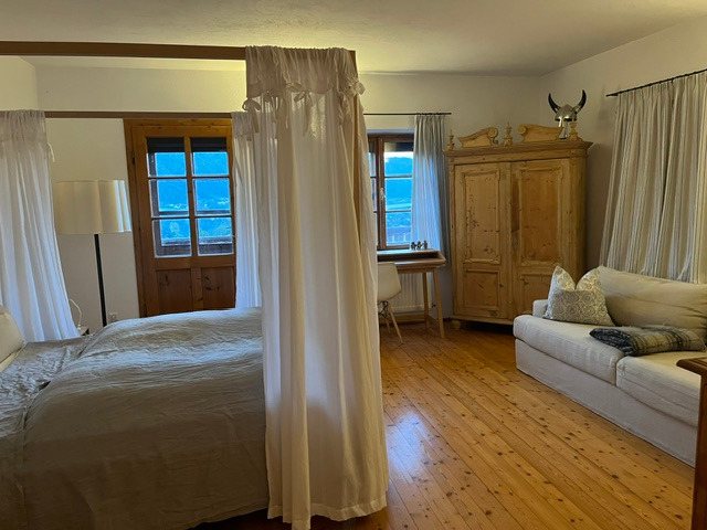 Schlafzimmer mit Himmelbett, Bauernschrank und Seeblick