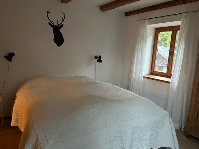 Schlichtes Schlafzimmer mit weißer Tagesdecke