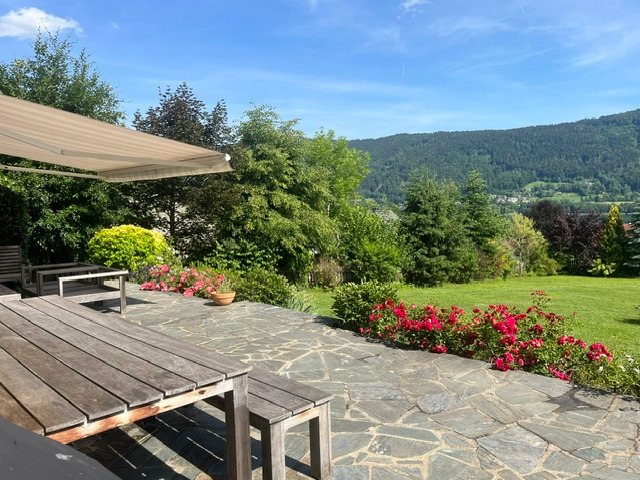 Steinterrasse mit Markise, Teaktisch und Blick auf den See